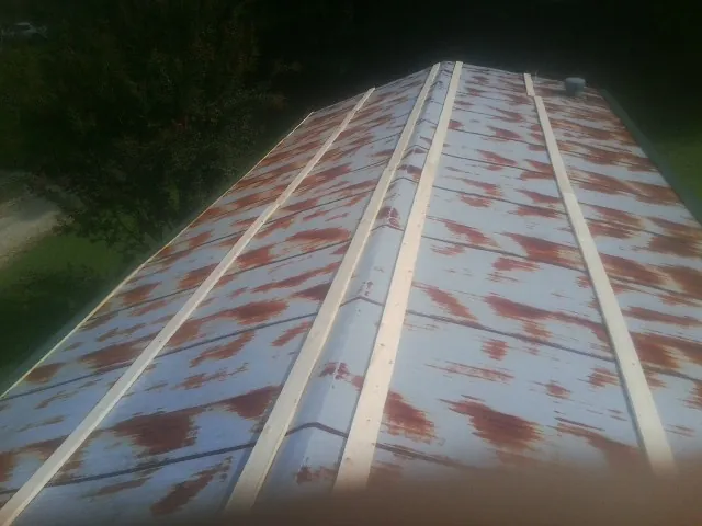 Rusted metal roof panels with new wood purlins before replacement — Storm Damage Roof Repair in Cazenovia by Roofing Brothers