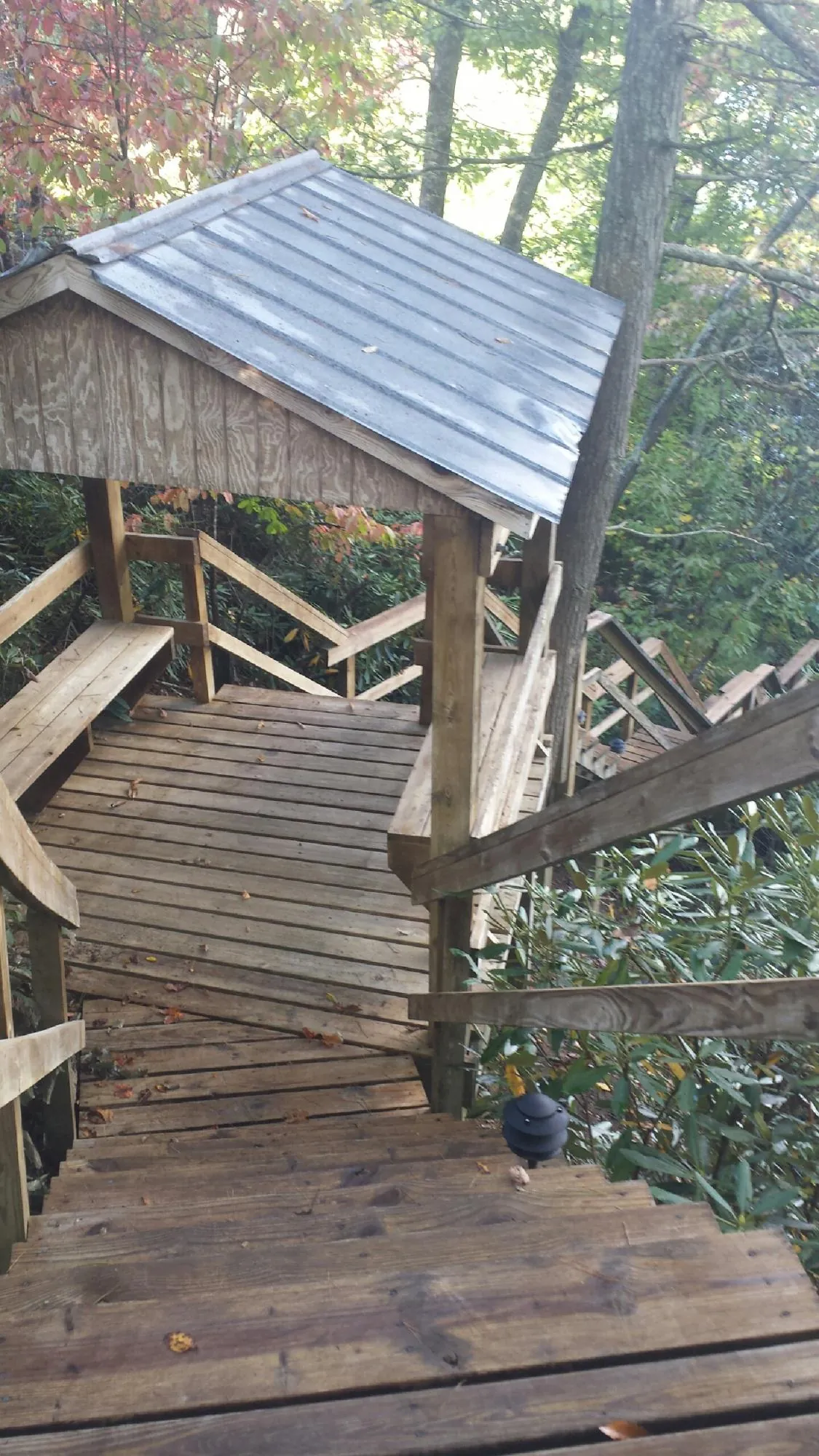 Metal roofed shelter over wooden steps on a wooded walkway — Skylight Repair & Installation work by our crew in Cazenovia