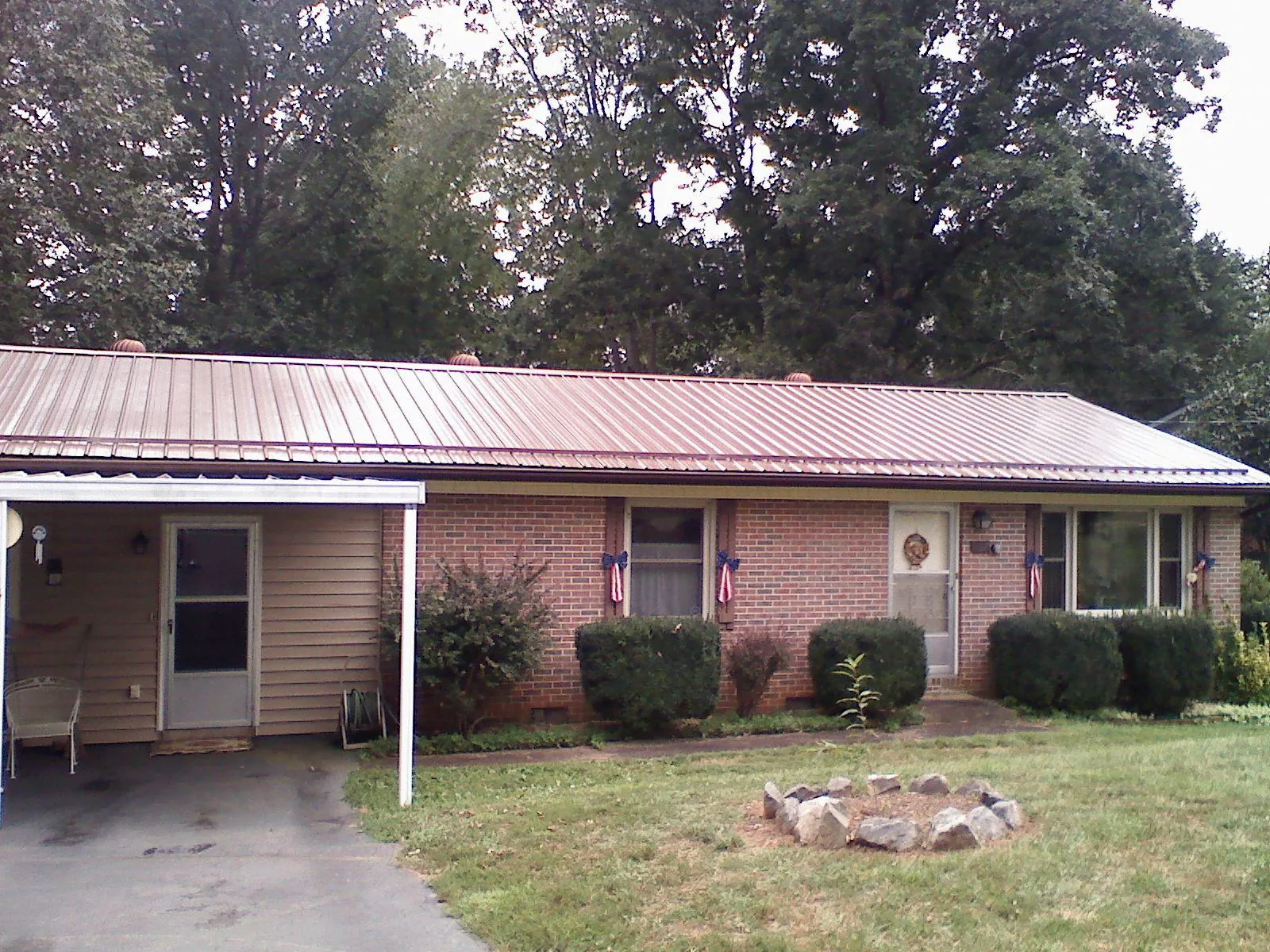 Bronze metal roof and carport on a brick ranch home — Roof Repair work by our crew in Cazenovia